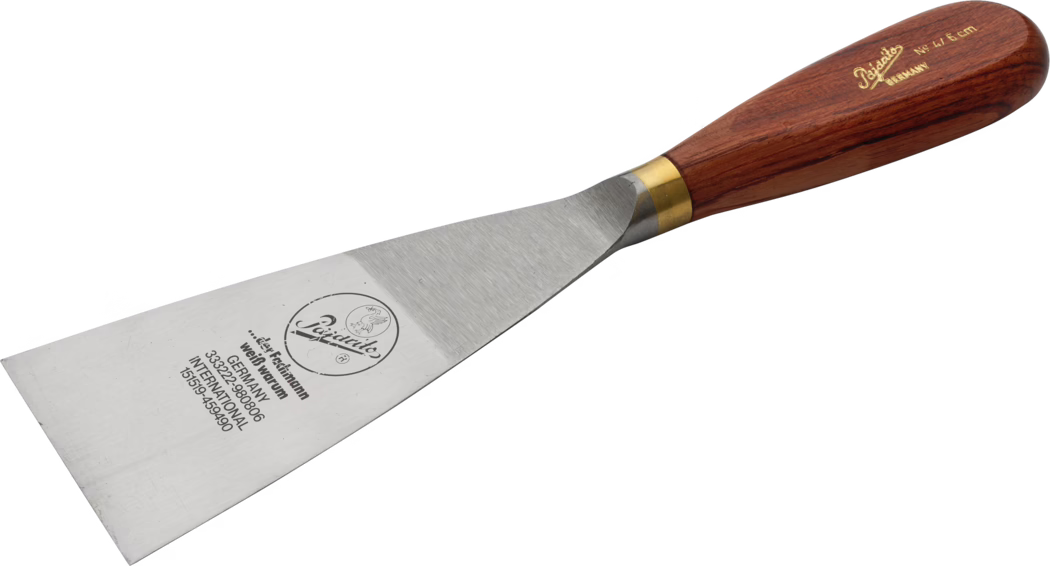Pajarito_Dummy_Goiter spatula precious wood w brass_034461_034459_060041_060042_060043_034497_2021-02 Steel putty knife with a wide rectangular blade and a wooden handle fitted with a brass ferrule; the blade shows a brand logo and stamped text. Tool is used for scraping and spreading plaster or putty. Photograph on a white background, angled view.